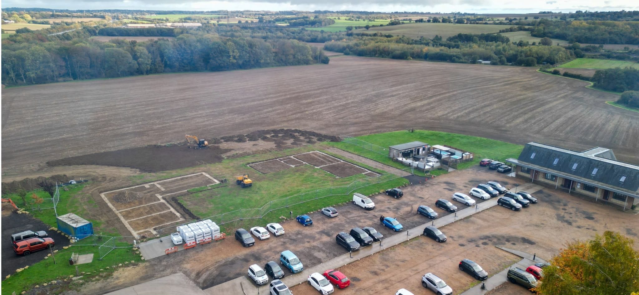 Wide aerial of the Evegate site with foundations laid out in the field